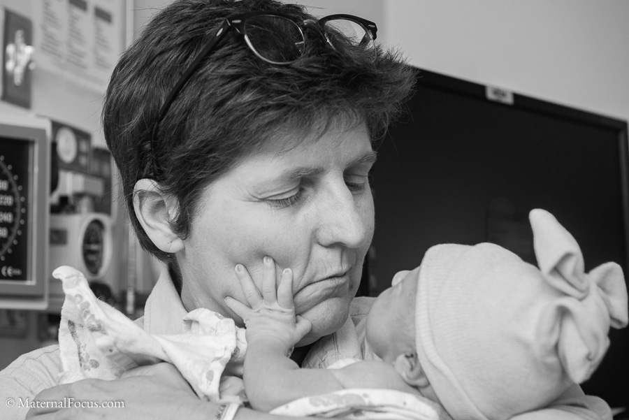 Newborn touching mama's cheek