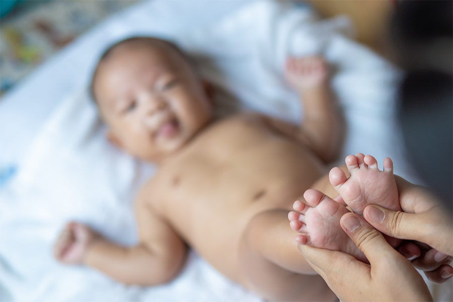 Newborn baby having feet massaged