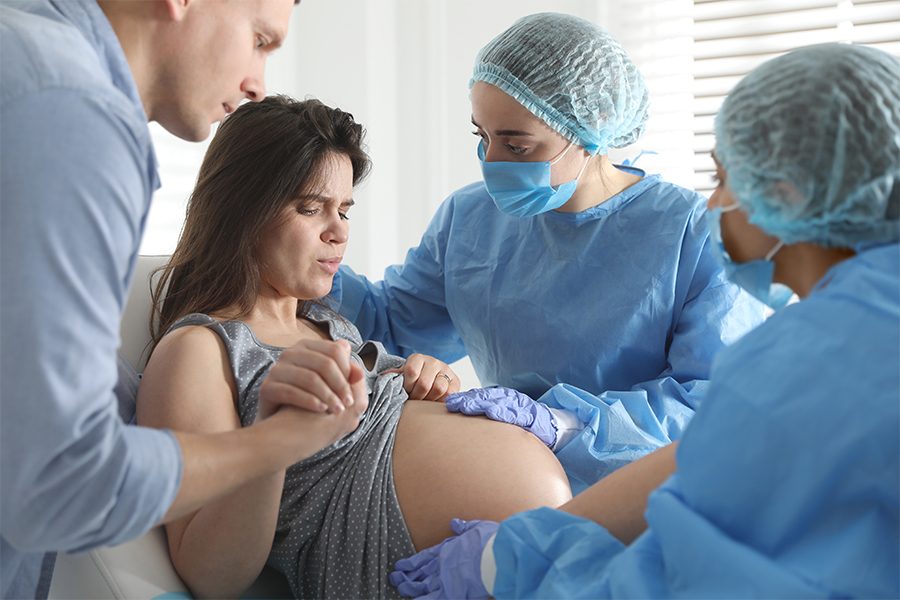 Nurses assisting a laboring person during pushing